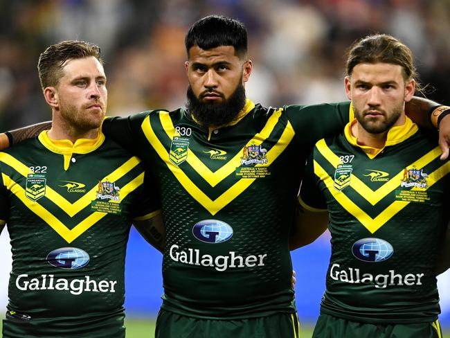 TOWNSVILLE, AUSTRALIA - OCTOBER 14: James Tedesco, Payne Haas and Patrick Carrigan of the Kangaroos stand for the national anthem before the Mens Pacific Championship match between Australia Kangaroos and Samoa at Queensland Country Bank Stadium on October 14, 2023 in Townsville, Australia. (Photo by Ian Hitchcock/Getty Images)