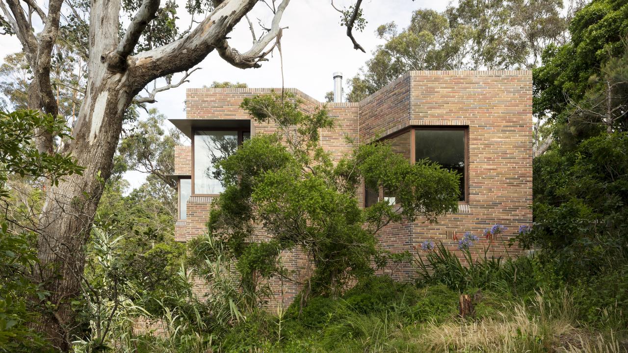 The house is nestled in the bush above a beach. Picture: Welsh + Major