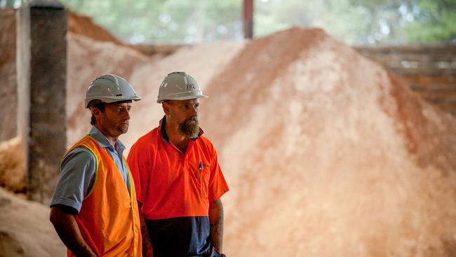 Austral Bricks Longford employees David Robertson and Jason Farrow in front of sawdust biomass used to heat the brick-making kilns. Picture: Supplied