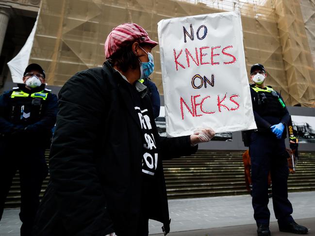 A demonstrator holds a placard in front of a police line while attending a Black Lives Matter protest to express solidarity with US protesters in Melbourne. Picture: AAP