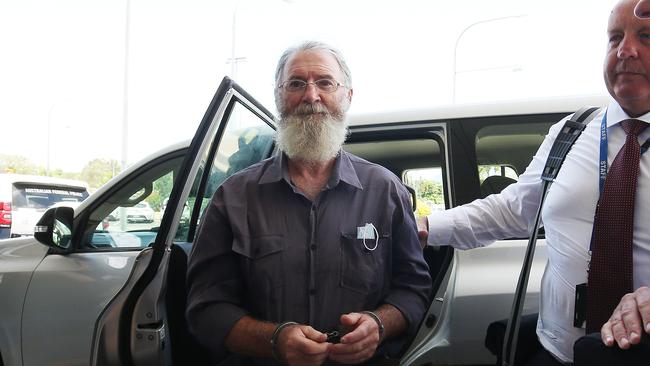 Queensland and Victorian police officers walk fugitive Graham Gene Potter through the Cairns International Airport to extradite him to Victoria. Picture: Brendan Radke