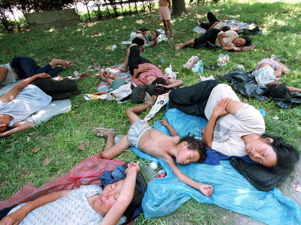 Workers take a break in the shade in Beijing during a heatwave. Picture: AFP