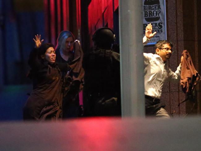 Hostages Harriette Denny, Julie Taylor and Viswakanth Ankireddy escape the Lindt Cafe. Photo: AP/ Rob Griffith