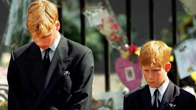 Prince William and Prince Harry with bowed heads outside Westminster Abbey.