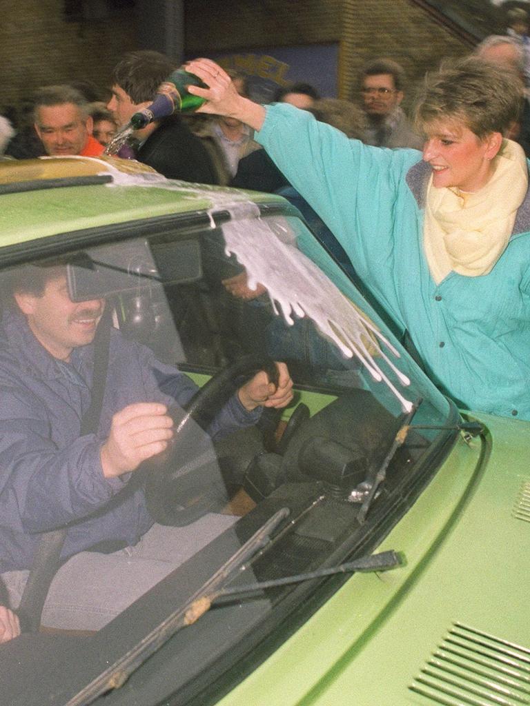 A West Berliner douses an East Berliner in champagne as he drives his car to the West. Picture: Patrick HERTZOG / AFP.