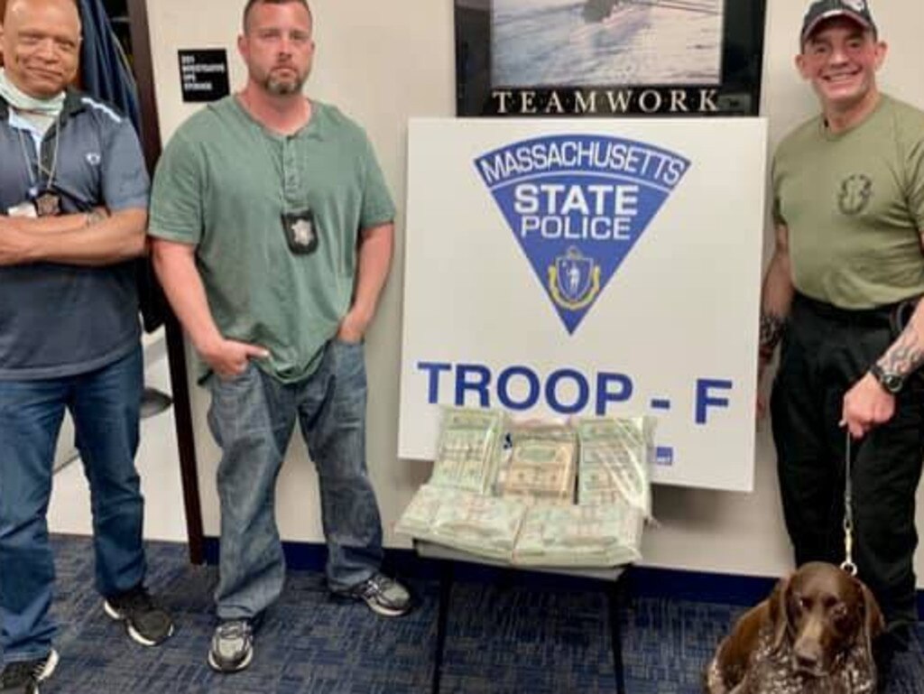 Authorities stand alongside the $A209k found on a passenger who missed a flight.
