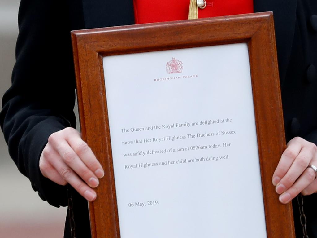 A member of staff carries the official notice of baby Archie’s birth to be set up on the  easel. Picture: AFP