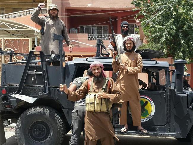 Australian fugitive Khaled Sharrouf (back of truck) in Syria with other ISIS extremists.