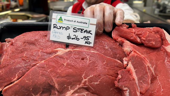 Butcher George Vourvahakis holds up a tray of Australian rump steaks at his store in the Melbourne suburb of Yarraville on May 12, 2020. - China suspended imports from four major Australian beef suppliers May 12, just weeks after Beijing's ambassador warned of a consumer boycott in retaliation for Canberra's push to probe the origins of the coronavirus. (Photo by William WEST / AFP)
