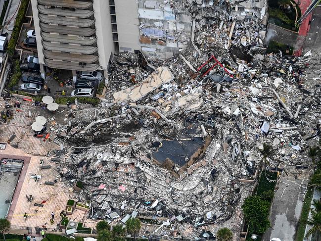 This aerial view, shows search and rescue personnel working on site after the partial collapse of the Champlain Towers South in Surfside, north of Miami Beach, on June 24, 2021. - The multi-story apartment block in Florida partially collapsed early June 24, sparking a major emergency response. Surfside Mayor Charles Burkett told NBCâs Today show: âMy police chief has told me that we transported two people to the hospital this morning at least and one has died. We treated ten people on the site.â (Photo by CHANDAN KHANNA / AFP)