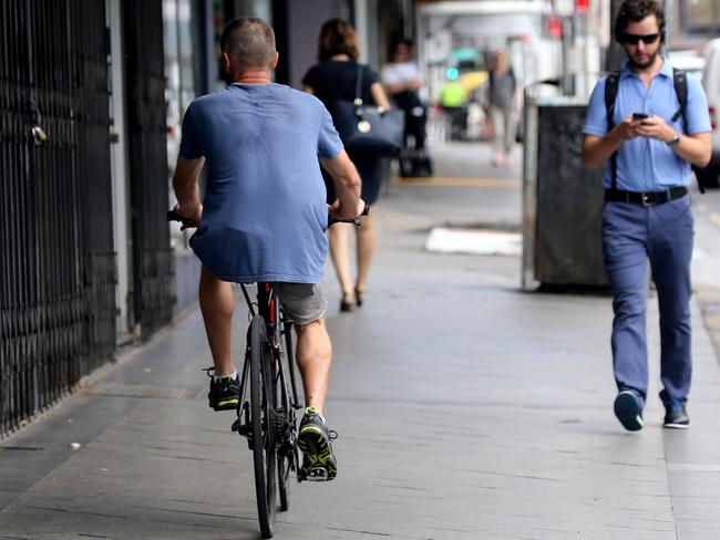 A bike rider without a helmet riding along a footpath today. Picture: John Grainger