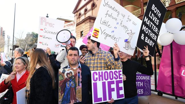 Anti-abortion advocates hold placards during a rally outside the New South Wales Parliament House in Sydney. Picture: AAP / Joel Carrett