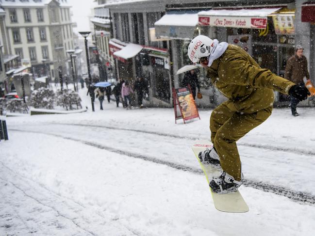 Sylvain rides his snowboard on a snow-covered street in Lausanne, Switzerland, Thursday, March 1, 2018. Persistent snow and freezing conditions from a Siberian cold snap  caused a handful of deaths across a swathe of Europe from Britain to the Balkans. (Jean-Christophe Bott/Keystone via AP)