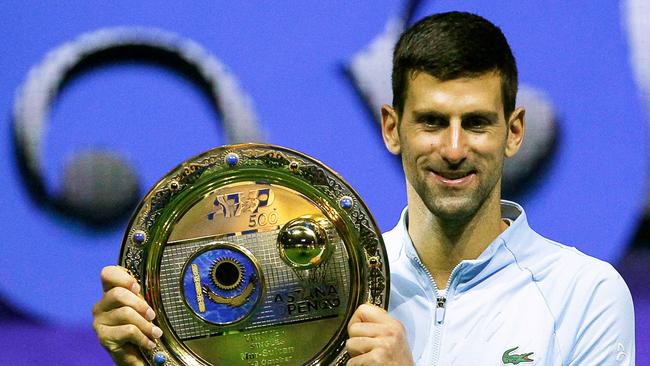 Serbia's Novak Djokovic celebrates with the trophy after defeating Greece's Stefanos Tsitsipas in their men's singles final match at the Astana Open