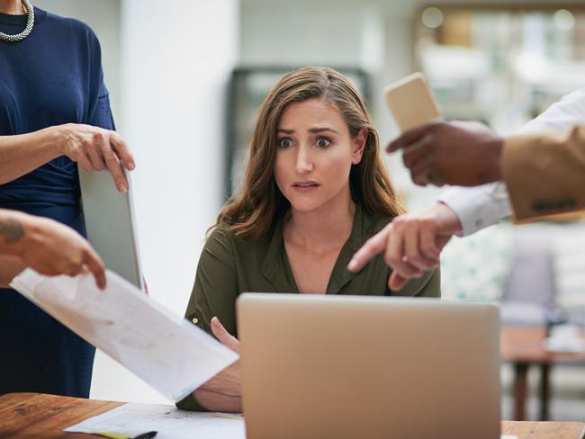 CAREERS: Shot of a young businesswoman looking anxious in a demanding office environment.