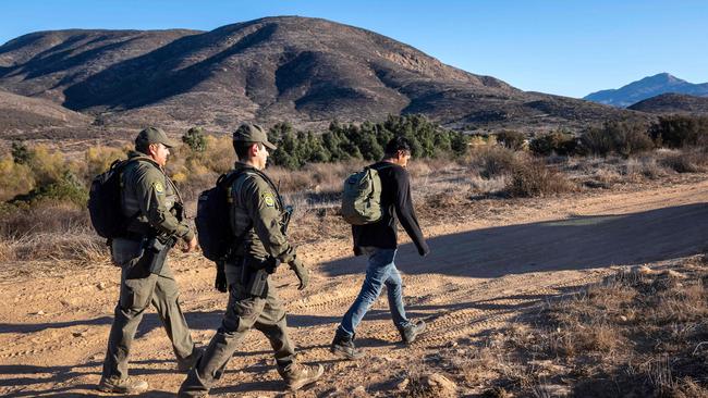 US. Border Patrol agents detain a migrant who had crossed the border from Mexico. Picture: Getty Images via AFP.