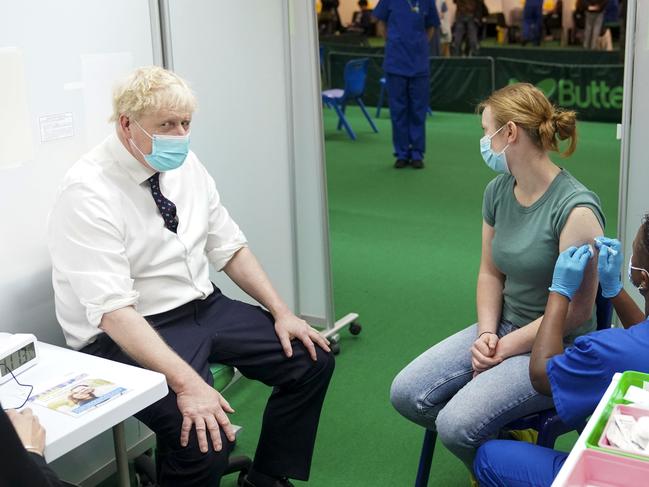 UK Prime Minister Boris Johnson sits with a member of the public as she receives her Covid-19 booster vaccination. Picture: AFP