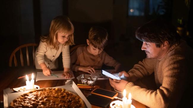 Family sitting at home with candles during blackout.