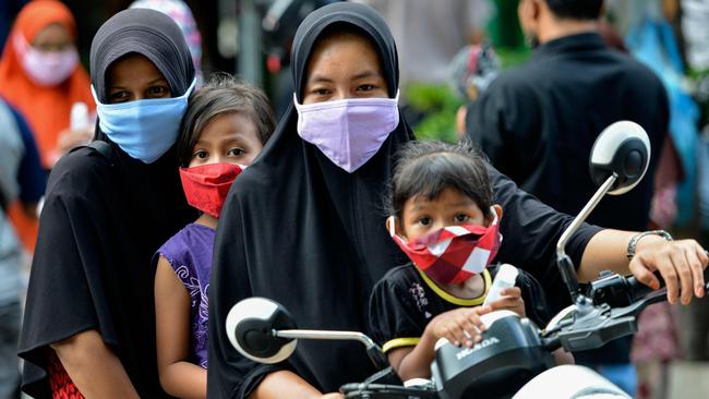 People wearing face masks, amid concerns of the COVID-19 coronavirus, commute on a street in Banda Aceh. Picture: AP