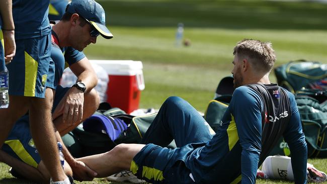 David Warner of Australia is assessed by Australian Team Physiotherapist David Beakley after being struck on the leg. Picture: Ryan Pierse/Getty Images