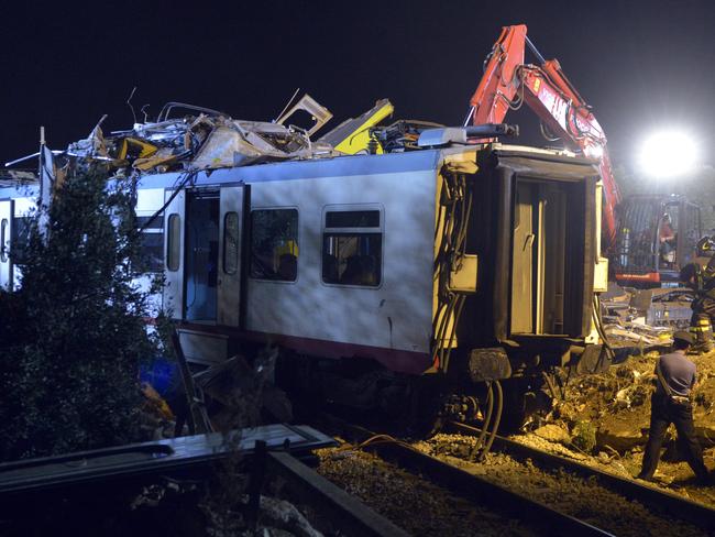 Rescuers work on the scene of a train accident in the southern region of Puglia, killing at least 25 passengers. Picture: AFP