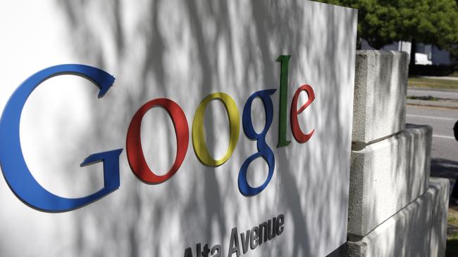 In this June 5, 2014 photo, a man walks past a Google sign at the company's headquarters in Mountain View, Calif. Google is buying Skybox Imaging in a deal that could serve as a launching pad for the Internet company to send its own fleet of satellites to take aerial pictures and provide online access to remote areas of the world. (AP Photo/Marcio Jose Sanchez)