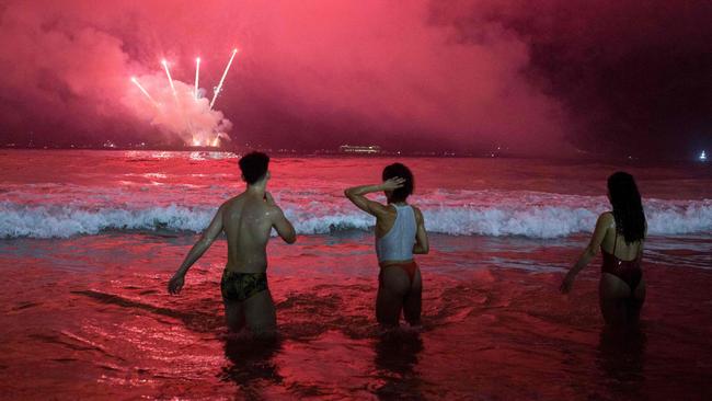 People celebrate as New Year's fireworks light up the sky at Copacabana Beach in Rio de Janeiro, Brazil, on Sunday. Picture: AFP