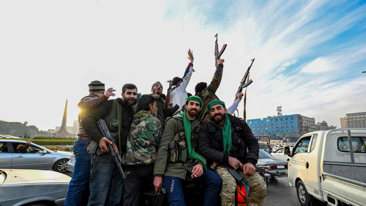 Anti-government fighters cheer from the back of a car near Umayyad Square. Picture: Louai Beshara/AFP