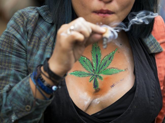 A young woman smokes a joint during a rally calling for the legalisation of marijuana, in Mexico City.