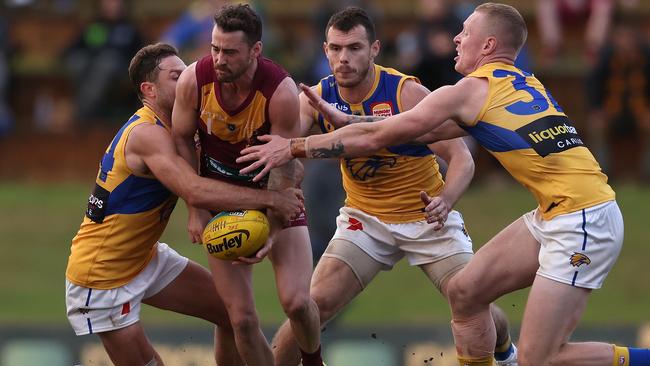 PERTH, AUSTRALIA - JUNE 19: Leigh Kitchin of the Lions gets tackled by Mark Hutchings of the Eagles during the WAFL Rd 11 match between the Subiaco Lions and West Coast Eagles at Leederville Oval on June 19, 2021 in Perth, Australia. (Photo by Paul Kane/Getty Images)