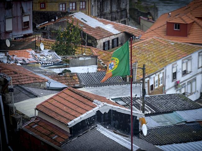 A Portuguese flag flutters above houses in Porto. Picture: AFP