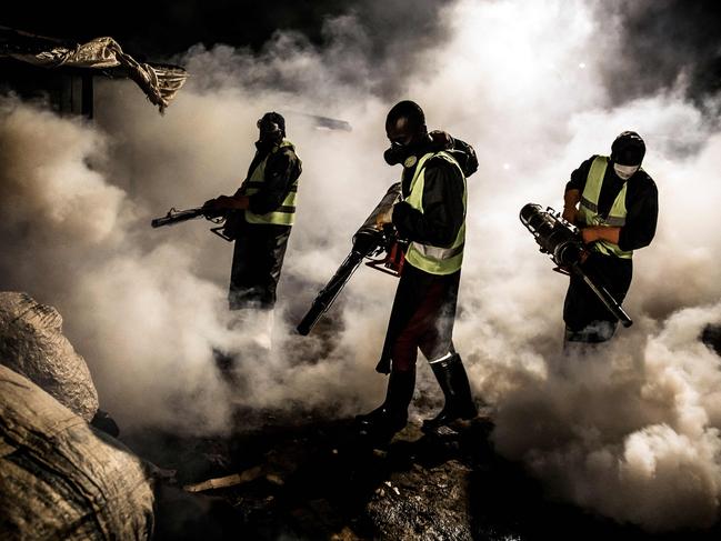 Officials wearing protective gear fumigate and disinfect on April 15, 2020, during the dusk-to-dawn curfew imposed by the Kenyan Government, the streets in Nairobi. Picture: AFP