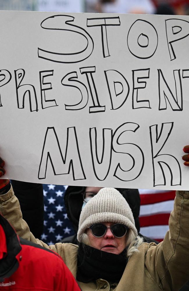 A person holds up a sign as they protest against US President Donald Trump and Elon Musk's "Department of Government Efficiency" (DOGE). Picture: AFP