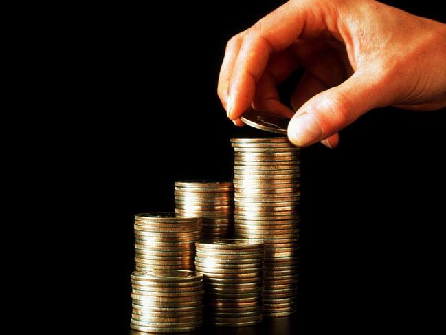 Person making stack of one dollar coins. stacking money pile /Money/Australia