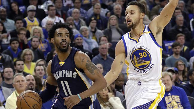 Memphis Grizzlies' Mike Conley (11) dribbles past Golden State Warriors' Stephen Curry (30).