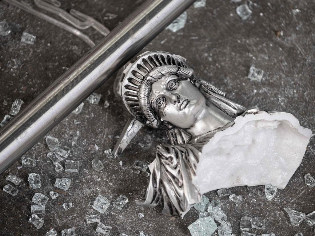 A broken Statue of Liberty figure between glass shards outside a souvenir shop. Picture: Johannes Eisele/AFP