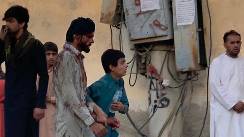 Injured Afghans flee the site of a suicide bombing next to Kabul airport on Thursday. Picture: Twitter