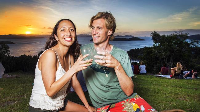 Honeymooners Chrissy and Andrew Skalitzky from California enjoy a sundowner on One Tree Hill at Hamilton Island. Picture: Lachie Millard