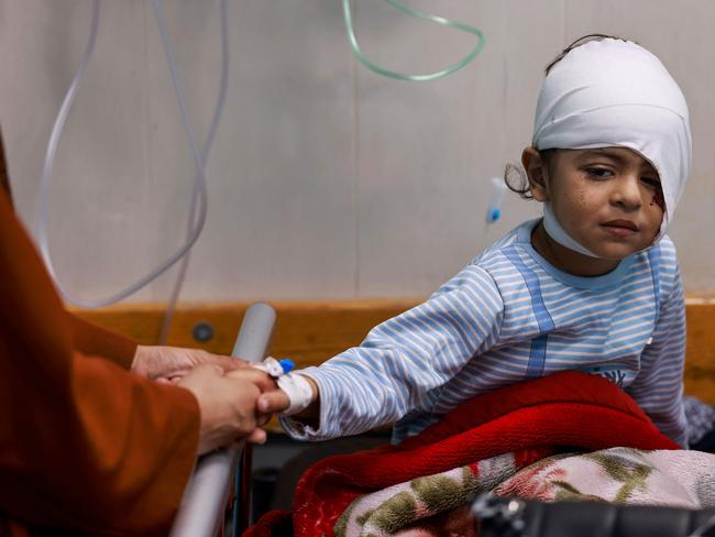 A wounded Palestinian child from the Jabalia refugee camp sits on a bed after being transferred from the Indonesian Hospital in the north to the Naser Hospital in Khan Yunis. Picture: AFP