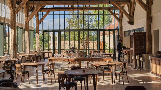 The restored barn of Le Doyenné serves as the dining room and open kitchen. Picture: Luke Burgess