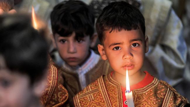 Children hold candles during the Palm Sunday service at St Porphyrius in Gaza City. Picture: AFP