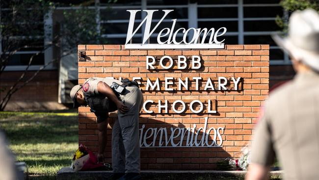 A Texas State Trooper receives flowers for the victims of a mass shooting at Robb Elementary School. Picture: Jordan Vonderhaar/Getty Images/AFP.