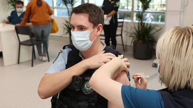 A police officer is injected at the Covid-19 Vaccination Centre at Sydney’s Olympic Park. Westpac chief executive Peter King says vaccination is the key to getting life back to normal. Picture: David Swift