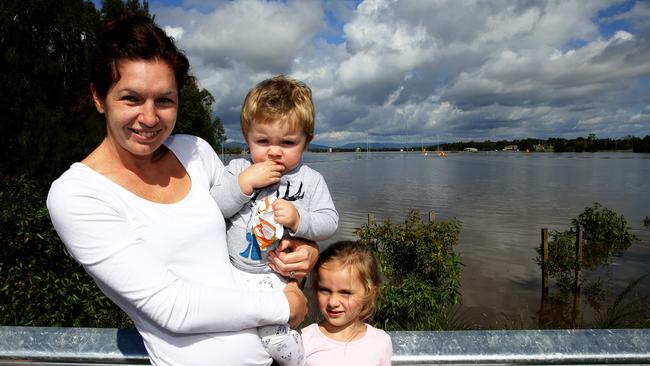 Jess Bellott and children Ava, 4, and Nixon, 1, are trying to get back to marooned Gillieston Heights.