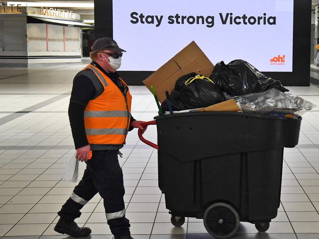 A worker pushes a bin at Melbourne's Flinders Street station on September 17, 2020. - Australia's unemployment rate on September 17 fell slightly to 6.8 percent in August, spurring hopes that the worst of a coronavirus-fuelled recession may have passed. (Photo by William WEST / AFP)