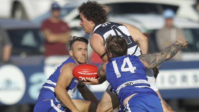 Noarlunga's Tom Mott handballs as he is about to be tackled by Port Noarlunga's Liam Lusty. Picture: AAP /Dean Martin