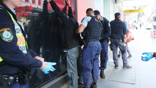 A man is searched and arrested by officers. Picture: John Grainger