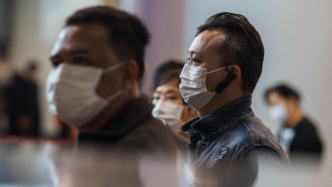 Passengers wearing masks queue at ticketing booths at a high-speed train station connecting Hong Kong to mainland China on January 26. Picture: Dale De La Rey/AFP