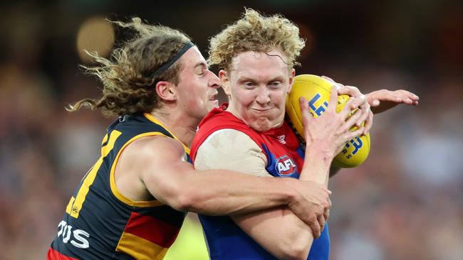 Clayton Oliver of the Demons breaks the tackle of Sam Berry of the Crows.