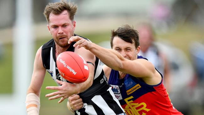 Sean Morris of Wallan handballs whilst being tackled during the round two RDFNL Bendigo Bank Seniors match between Diggers Rest and Wallan at Diggers Rest Recreation Reserve, on April 13,2024, in Diggers Rest, Australia. (Photo by Josh Chadwick)